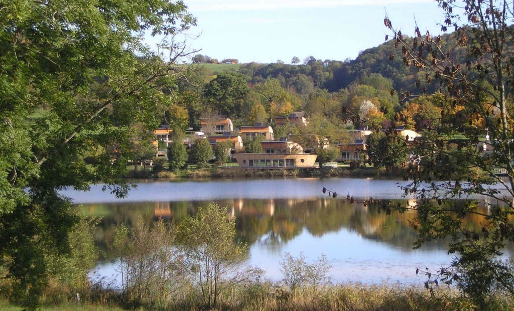 VILLAGE VACANCES DU LAC DE MENET ****, Vue du village vacances de l\'autre rive. Camping Auvergne : Le calme au bord du lac de Menet. Venez passer des vacances reposante face à un volcan.