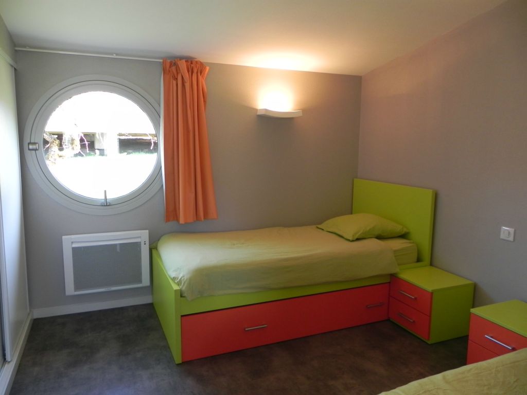 VILLAGE VACANCES DU LAC DE MENET ****, Chambre enfant aux couleurs des vacances. Camping Auvergne : Chambre enfants : 3 lits de 90x190