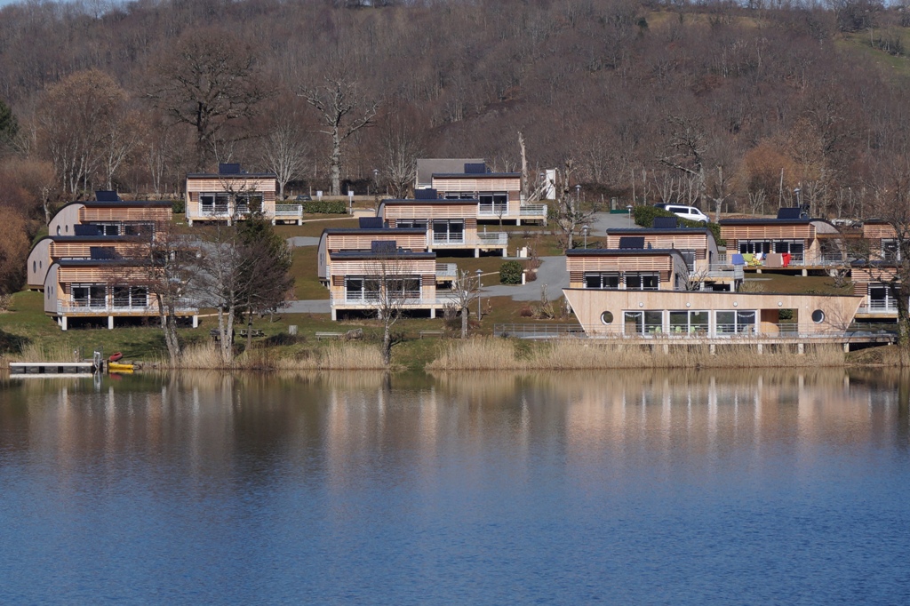 VILLAGE VACANCES DU LAC DE MENET ****, Les chalets de vacances vue de l\'autre rive du lac. Camping Frankrijk Auvergne : Vue du village vacances du lac de Menet. Lieu idéal pour des vacances en famille, entre amis, en couple.
Les pieds dans l'eau, les chalets sont à quelques mètres du lac.